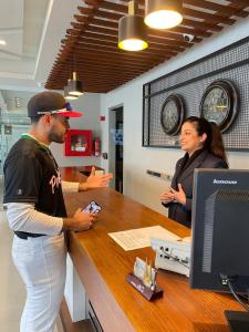 a baseball player standing at a counter with a woman at Sintra Hotel in Islamabad