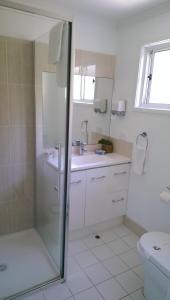 a bathroom with a shower and a sink and a toilet at Sails Lifestyle Resort in Peregian Beach