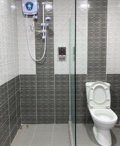 ein Bad mit einem WC und einer Dusche in der Unterkunft TAMU KoGURU in Jertih