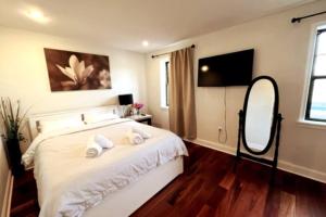 a bedroom with a bed with a mirror and a television at Modern Cozy Unit Near Geno's & Pat's in Philadelphia