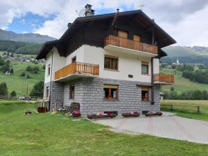 a house with a gambrel roof on top of it at Il Pettirosso - Appartamento Panoramico con 3 Camere in Villetta in Champoluc +19 photos
