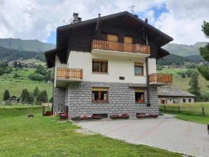 a house with a balcony on top of it at Il Pettirosso - Appartamento Panoramico con 3 Camere in Villetta in Champoluc