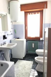 a bathroom with two toilets and a sink and a window at Il Pettirosso - Appartamento Panoramico con 3 Camere in Villetta in Champoluc