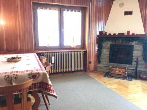a living room with a table and a fireplace at Il Pettirosso - Appartamento Panoramico con 3 Camere in Villetta in Champoluc
