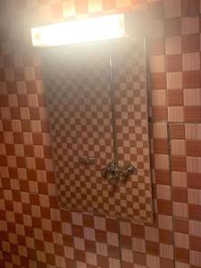 a bathroom with a tiled wall with a mirror at Sunrise Center Ngousso Yaounde in Yaoundé