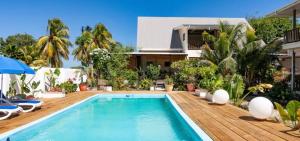 a villa with a swimming pool and a house at Hyde-Tide Guesthouse in La Digue