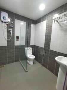 ein Bad mit einem WC, einer Dusche und einem Waschbecken in der Unterkunft TAMU KoGURU in Jertih