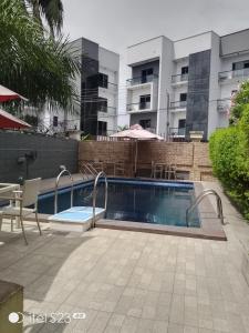 a swimming pool in front of a building at Ellyxville Hotel in Lekki
