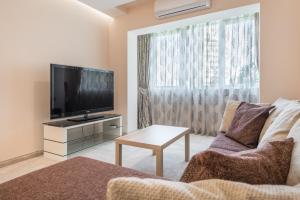 a living room with a couch and a flat screen tv at Private Apartment in Chayka near the Sea Garden in Varna City