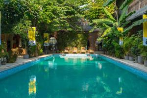 a swimming pool in the middle of a building with trees at The Artist House Udaipur in Udaipur