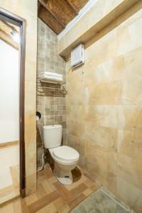 a bathroom with a white toilet in a room at Nirmala Guest House Surf Keramas in Keramas