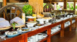 ein Buffet mit Tellern und Schüsseln. in der Unterkunft Chez Carole Beach Resort Phu Quoc in Phu Quoc