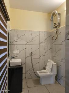 ゴカルナにあるPoornima Beach Stayのバスルーム(トイレ付)、壁掛け電話が備わります。