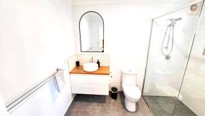 ウォンサッギにあるRR Guest Roomsのバスルーム(洗面台、トイレ、鏡付)