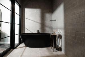 baño con bañera negra y ventana en St Hugh Hotel Wagga Wagga, en Wagga Wagga