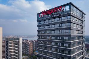 wysoki budynek z znakiem na górze w obiekcie Hampton by Hilton Chengdu Xibo City w mieście Chengdu