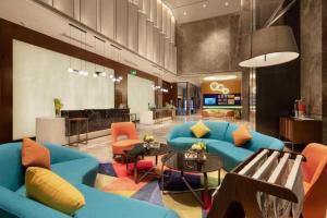 a lobby with a blue couch and chairs and a table at Hampton by Hilton Chengdu Xibo City in Chengdu