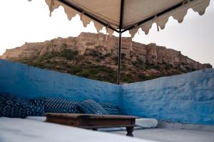 a bedroom with a blue wall with a mountain view at Bristows Haveli Homestay in Jodhpur