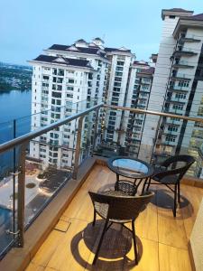 een balkon met 2 stoelen en een tafel op een gebouw bij Cozzzy hut @ Riverine Diamond Kuching in Kuching