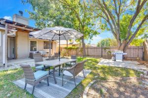 a patio with a table and chairs and an umbrella at Charming and Comfort 3BR/2BA Retreat in Kyle in Kyle