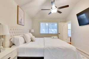 1 dormitorio con 1 cama blanca y ventilador de techo en Charming and Comfort 3BR/2BA Retreat in Kyle, en Kyle
