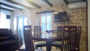 a dining room with a table and chairs and a tv at Holiday Home Peruski in Peruški