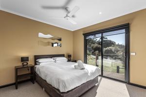 um quarto com uma cama e uma grande janela em Wye Vista em Wye River