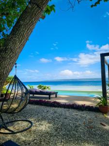 a swing hanging from a tree next to a beach at South Pacific Memories in Port Vila