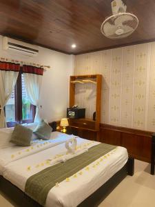 - une chambre avec un grand lit et un miroir dans l'établissement Golden Lotus Place, à Luang Prabang