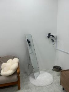 un espejo sentado junto a una silla en una habitación en Juzt Homestay Kpg Boyan, en Taiping
