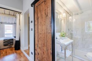 a bathroom with a wooden door and a sink and a shower at Toscana Lucca centro attico esclusivo con grande terrazza panoramica in Lucca +37 photos
