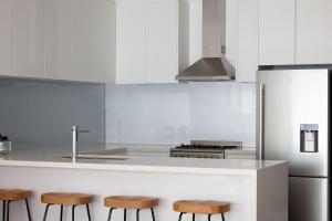 a kitchen with a counter with stools and a stove at Boutique Stays - Two Plus Two in Melbourne