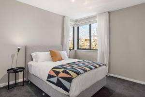 een slaapkamer met een groot bed en een raam bij Boutique Stays - Elmtree in Melbourne