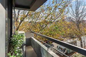 een balkon met uitzicht op een boom bij Boutique Stays - Elmtree in Melbourne