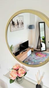 um espelho numa sala de estar com flores sobre uma mesa em Apartment in central Windsor em Windsor