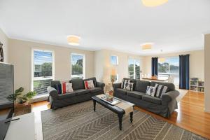 a living room with two couches and a table at Twin Beaches Retreat Cowes in Cowes