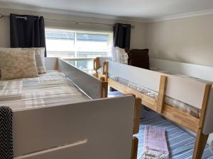 Zimmer mit 2 Etagenbetten und einem Fenster in der Unterkunft Twin Beaches Retreat Cowes in Cowes