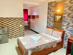a small bedroom with a bed in a room at Aosmec Square Hotel in Mactan