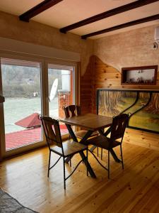 a dining room with a table and chairs and a window at Mini Deluxe Apartman Nature Connection Drina in Bajina Bašta
