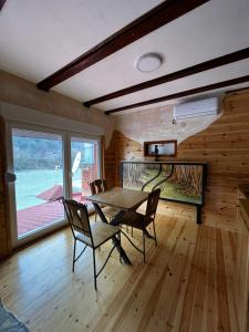 a dining room with a table and chairs and a large window at Mini Deluxe Apartman Nature Connection Drina in Bajina Bašta