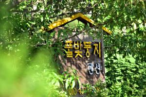 un cartel en un árbol con escritura en él en Yangyang Pulbit Pension, en Yangyang