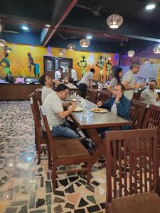 Misty Meadows, Lonavala في لونافالا: مجموعة من الناس يجلسون على طاولة في مطعم