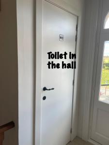 eine Tür mit einem Schild mit den Worten Toilette im Flur in der Unterkunft B&B L’Orangerie in Lo-Reninge