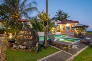 克拉玛斯Nirmala Guest House Surf Keramas的带游泳池和房子的别墅