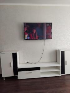 uma sala de estar com televisão na parede em Квартира em Karaganda