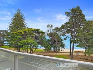 a view of a beach and trees from a balcony at 341 The Waves, Cowes in Cowes