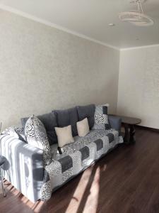 un soggiorno con divano e tavolo di Квартира a Karagandy