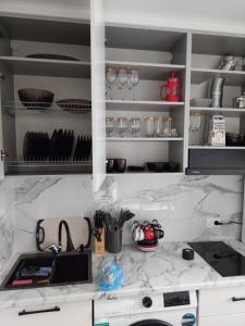a kitchen with white marble counter tops and a sink at Квартира in Karagandy
