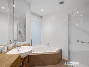 a bathroom with a tub and a sink and a shower at 341 The Waves, Cowes in Cowes
