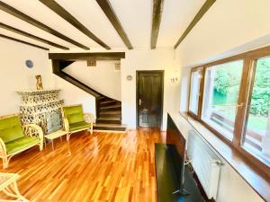 ein Wohnzimmer mit einer Treppe und grünen Stühlen in der Unterkunft Vila Titulescu in Sinaia